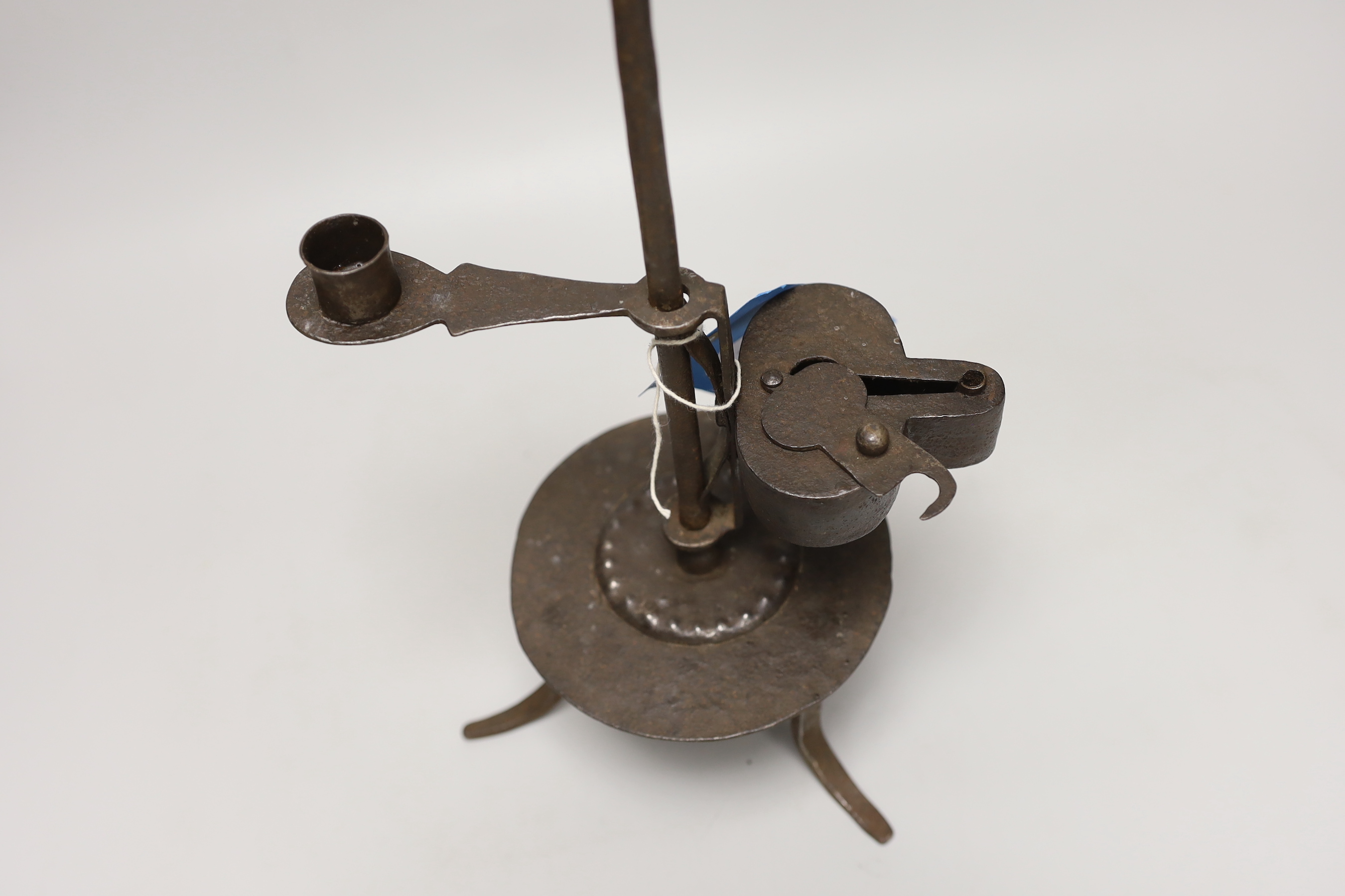 An 18th century Continental iron adjustable candle holder incorporating a crusie lamp, 41cm